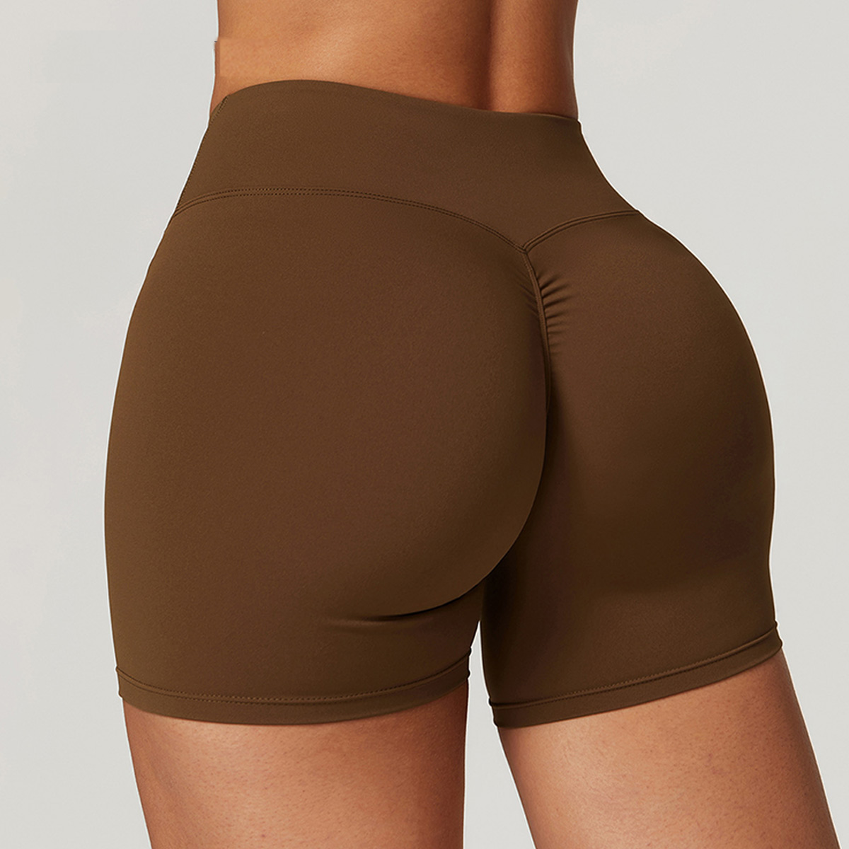 Brown athletic shorts worn by a person on a plain background